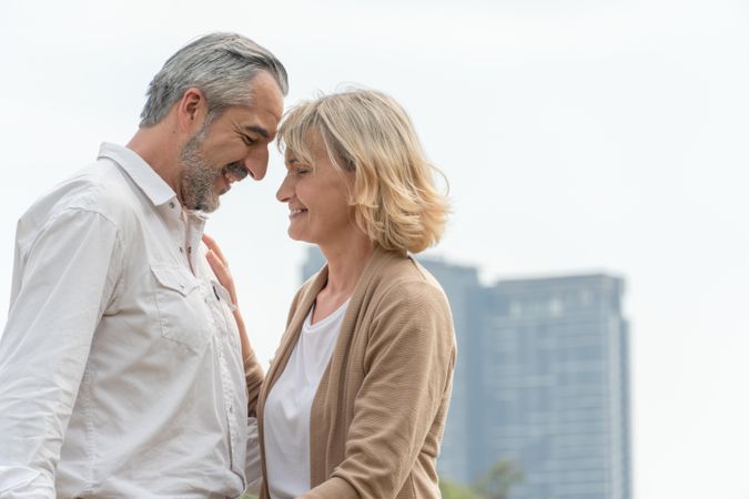 Male and female older couple facing each other with their eyes closed, copy space