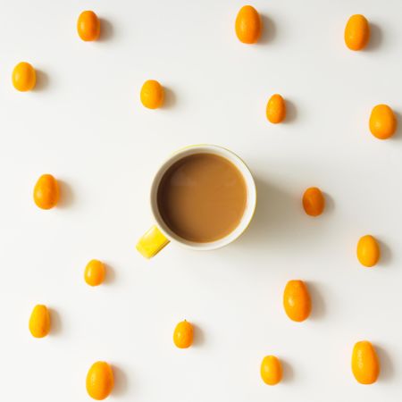 Pattern made of kumquats with coffee cup