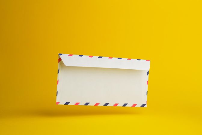 Floating envelope over light yellow background