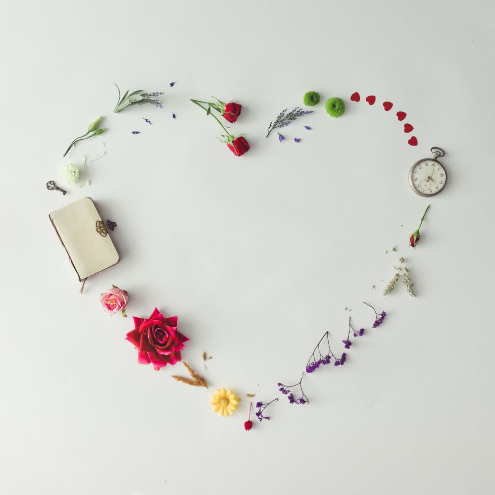 Layout with colorful flowers, leaves and heart shape