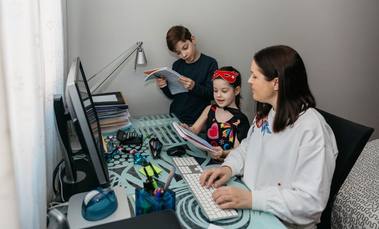 Woman teleworking and reviewing her children's homewor