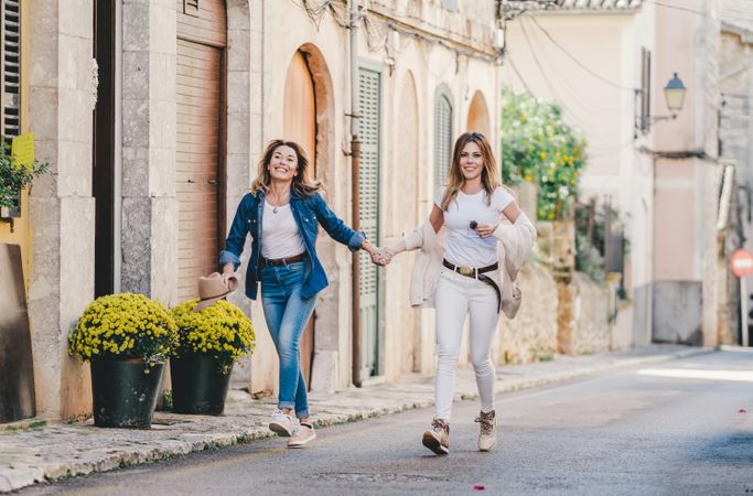 Friends having fun holding hands in street