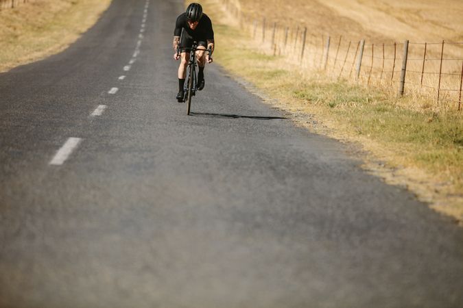Professional athlete cycling on countryside highway