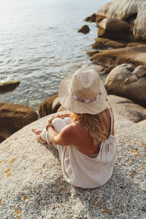 Carefree woman enjoying rest on coast near cliffs