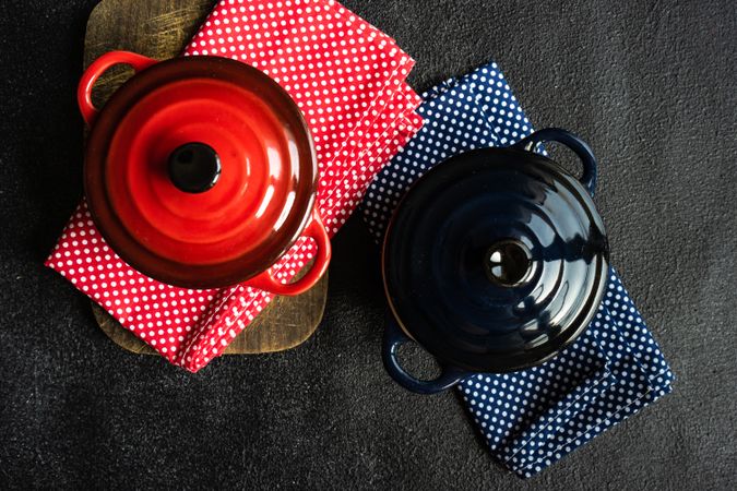Top view of two red & blue cast iron pan on kitchen towels