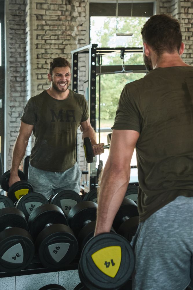 Strong man exercising with dumbbells in gym