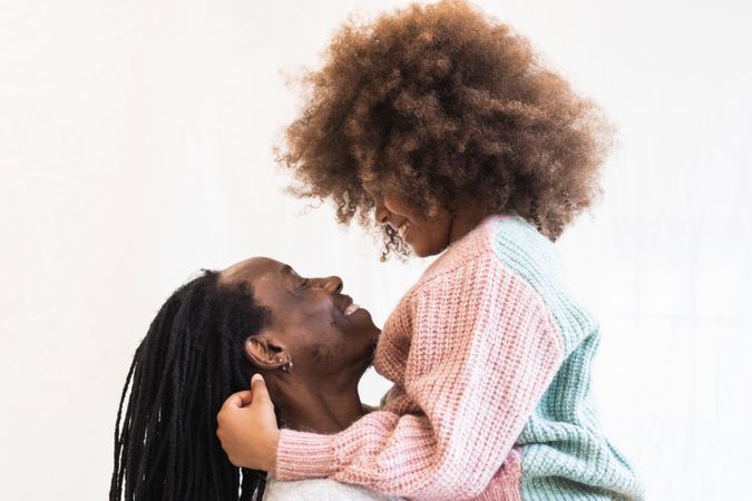 Black man carrying daughter on hands