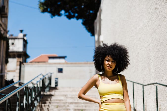 Stylish female standing on stairs with railing outdoors