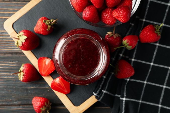 Composition with strawberry jam on wooden background, top view