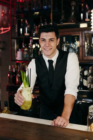Barman working preparing drink in a glass