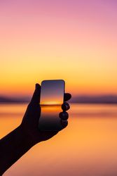 Man taking a sunset picture with his mobile