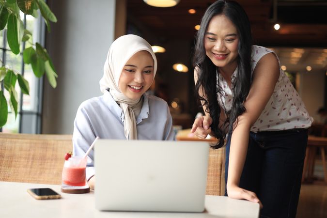 Two Asian Friends Working on Laptop at Coffee Shop