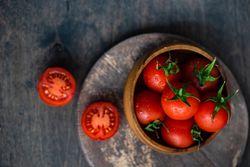 Top view of bowl of fresh tomatoes with one cut open