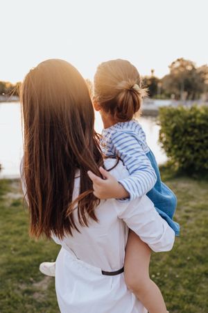 Mother and daughter standing near water