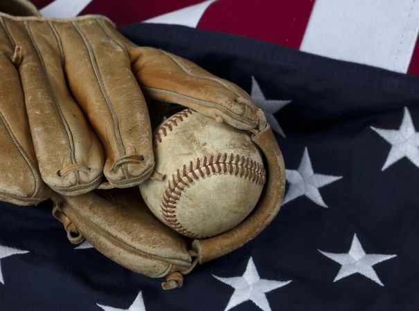 Old American Baseball and vintage glove on US Flag