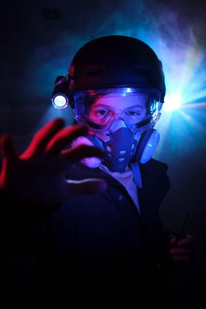 Boy in respirator committing robbery in darkness
