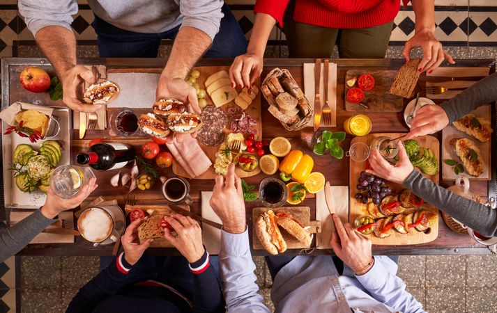 Faceless people sharing assortment of snacks