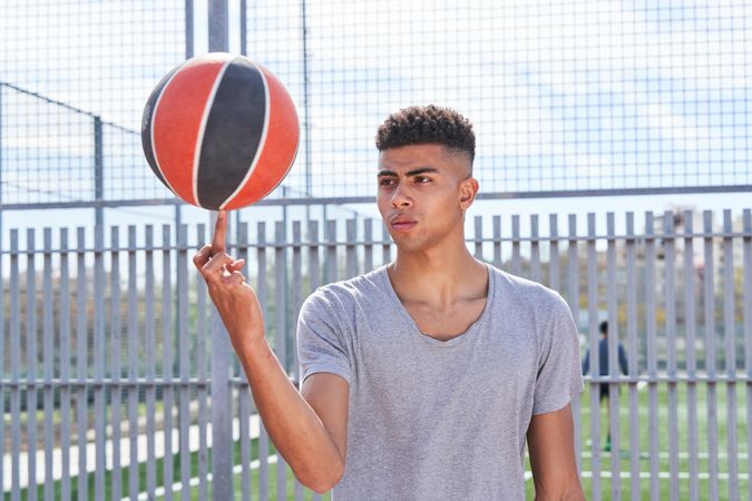 Latino male basketball player spinning ball