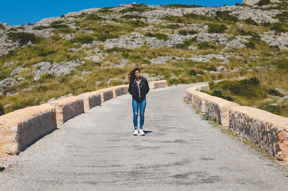 Woman standing on stony path in countryside
