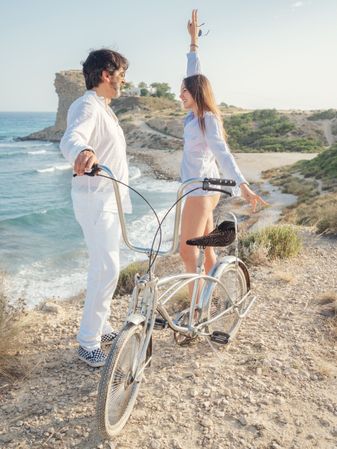 Man and woman holding bicycle at seaside