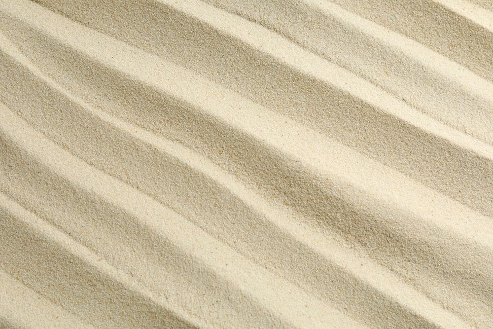 Clear sea sand as background, space for text and closeup. Summer vacation background