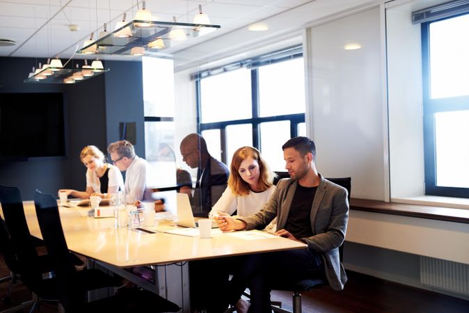 Colleagues sitting working together in meeting room