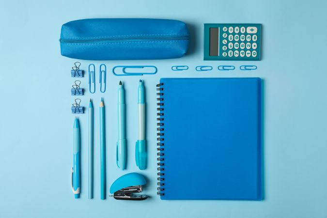 Flat lay with different school supplies on blue background