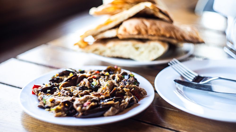 Traditional Georgian eggplant dish with vegetable served on a cafe table