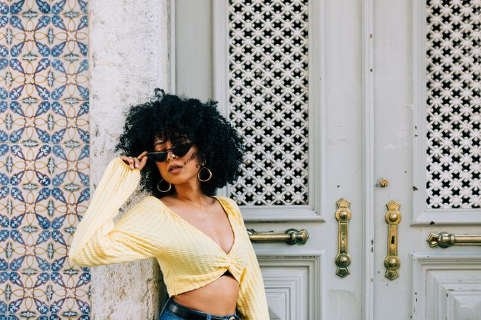 Happy Black female leaning on vintage door