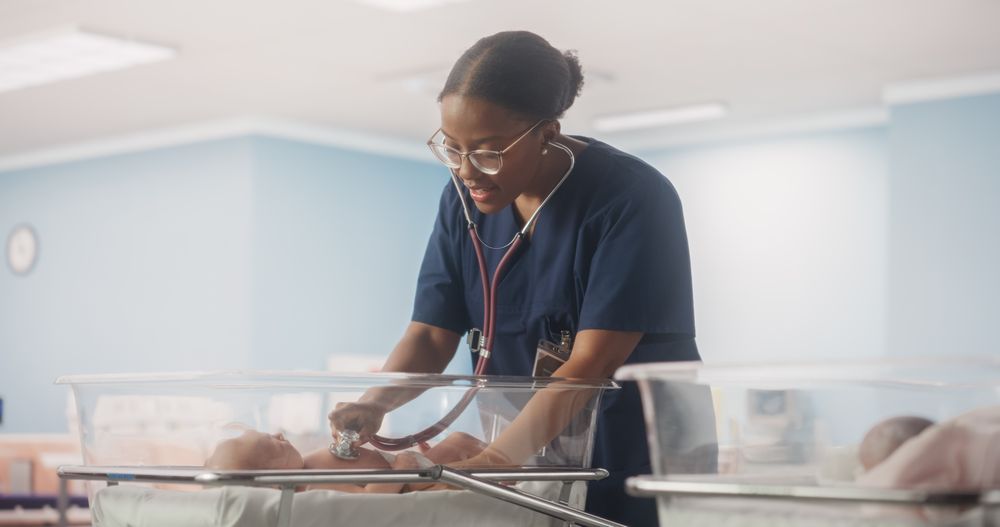Black Female Doctor Checking Up on a Child, Using Stethoscope in Nursery Clinic
