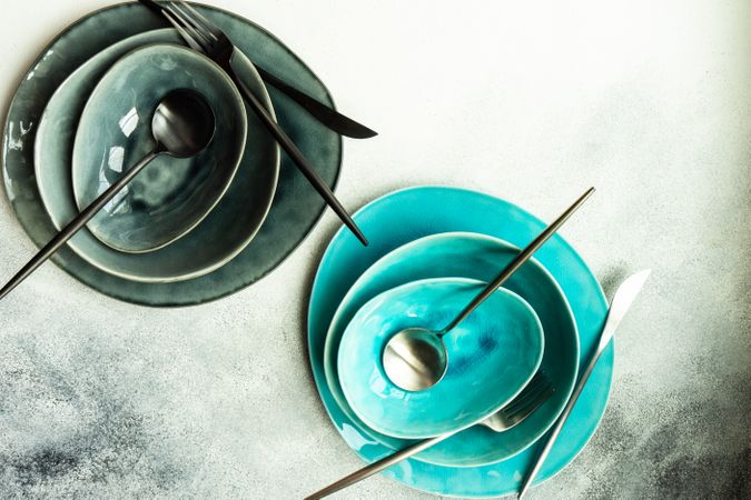 Top view of full grey & teal table setting with on grey background