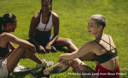 Group of three female soccer players relaxing on the field 5oZAy0