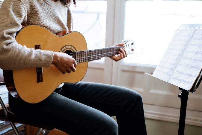 Woman playing guitar in studio