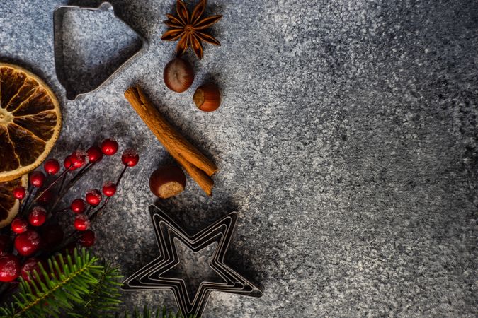 Top view of Christmas baking spices and cookie cutters on concrete counter