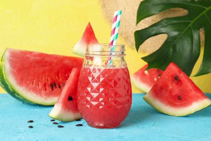 Composition with watermelon juice on blue table. Summer fruit