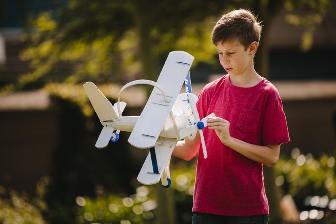 Boy playing with a toy plane outdoors