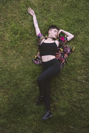 Woman in colored shirt lying on grass