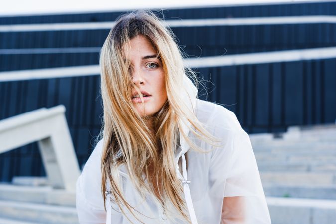 Charming stylish woman in raincoat on steps
