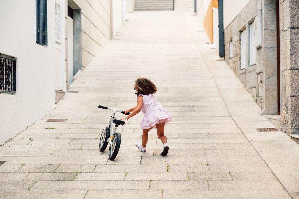 Girl riding on bicycle in narrow street