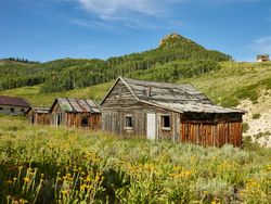 Old rustic wooden cabins in lush Colorado mountains E47JP5
