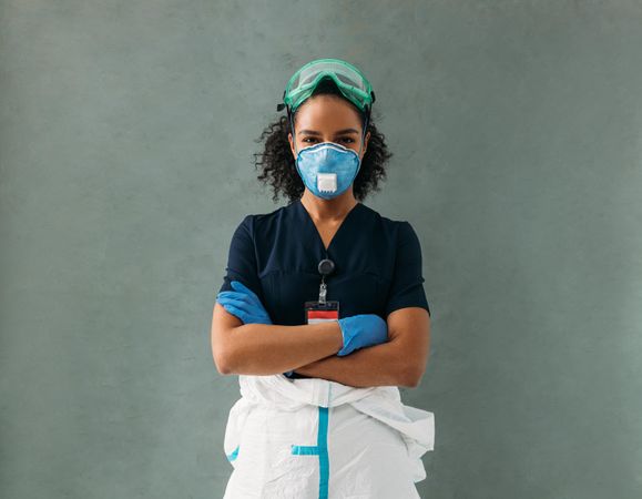 Nurse in PPE gear with top half of hazmat suit off