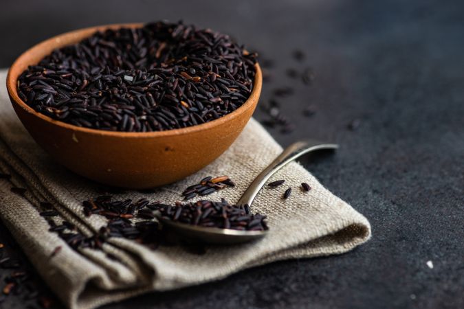 Organic dark rice in bowl with spoon on counter