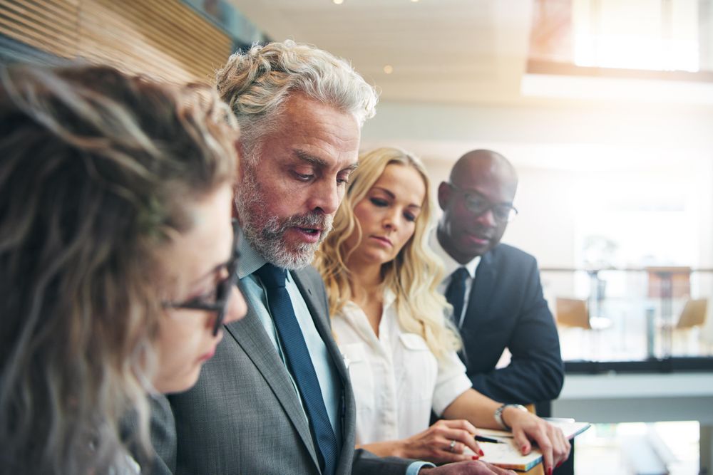 Group of serious colleagues standing having a conversation at work