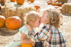 Sweet Little Boy Kisses His Baby Sister at Pumpkin Patch