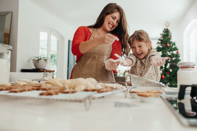 Mother and daughter having fun while baking for Christmas