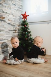 Happy babies near Christmas tree and gifts