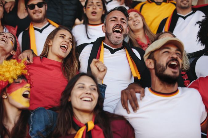 Group of man and woman enjoying watching a match