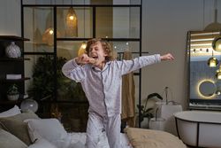 Carefree boy singing in bedroom