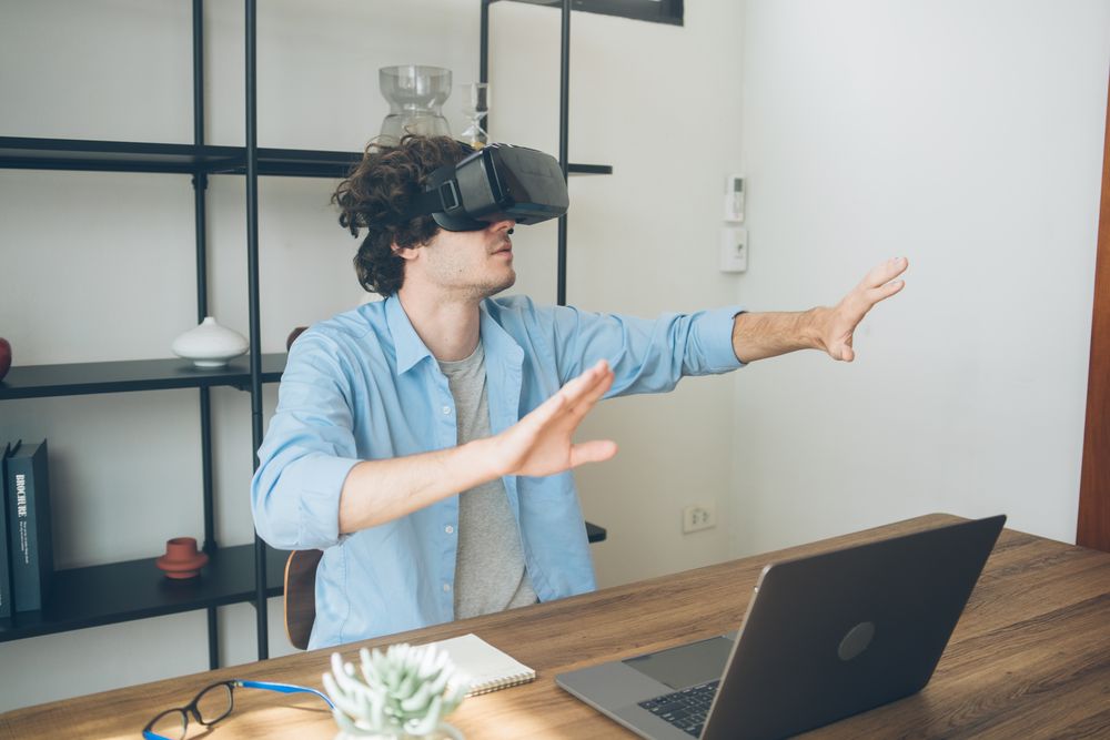 Male working in tech playing with VR glasses at home