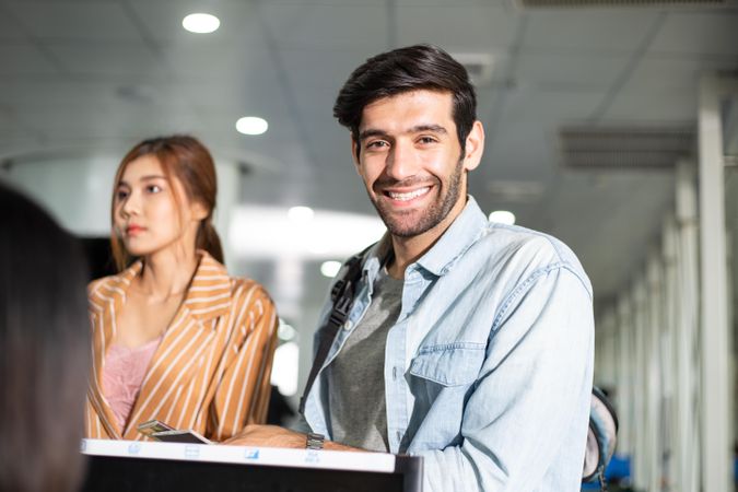 Happy male checking in for flight at airport